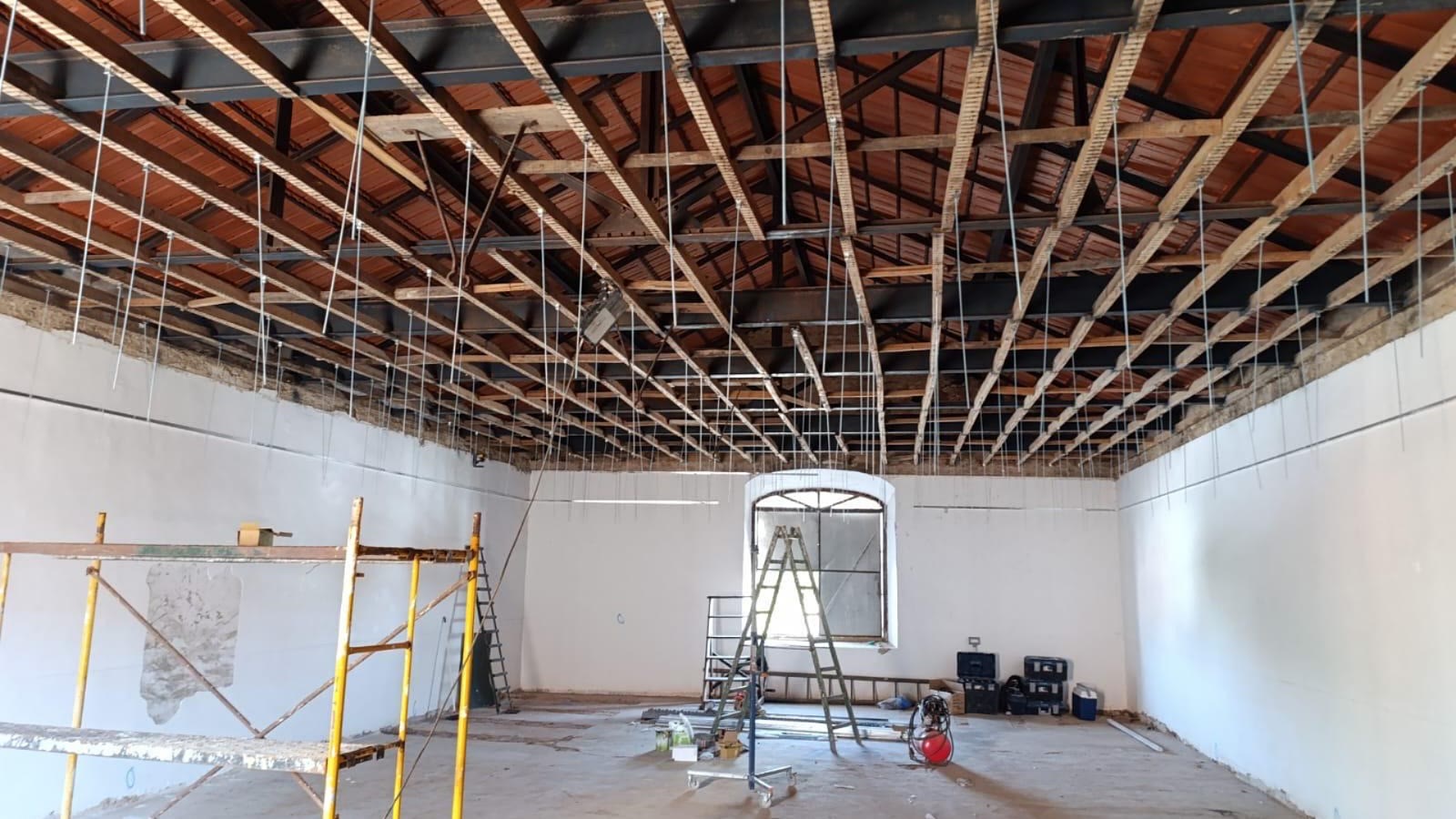 Estrutura de cobertura em fase de obra, com vigas à vista