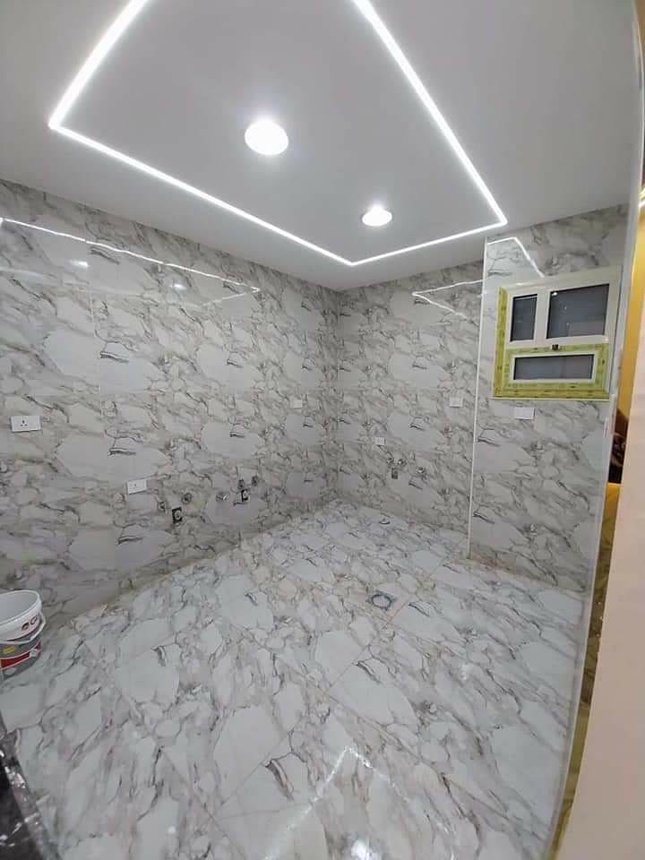 Casa de banho revestida a mármore com teto e iluminação LED
